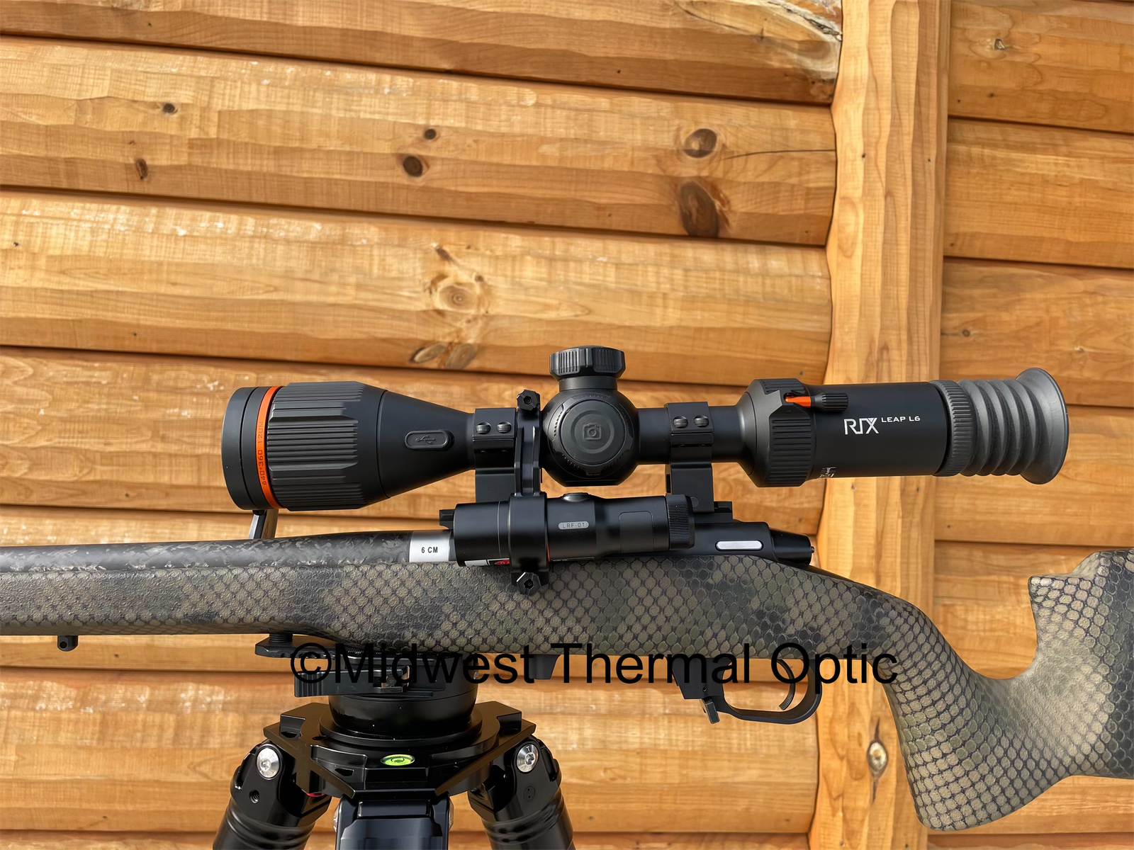 thermal scope with lrf mounted, wood wall behind product